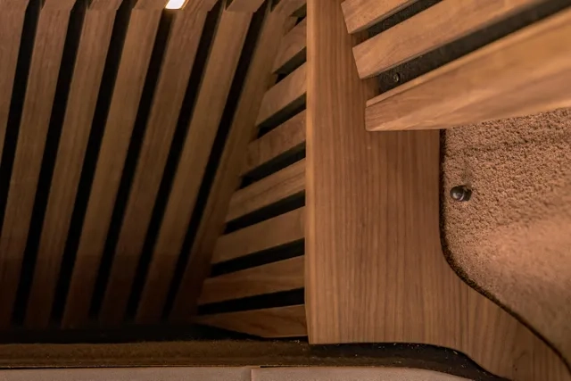 Aufwendige Schreinerarbeit im Camper Van von Cocoon Vans. Die Deckenverkleidung aus amerikanischen Nussbaum wurde zum sichtbaren Sprühkork aufwendig abgeschlossen